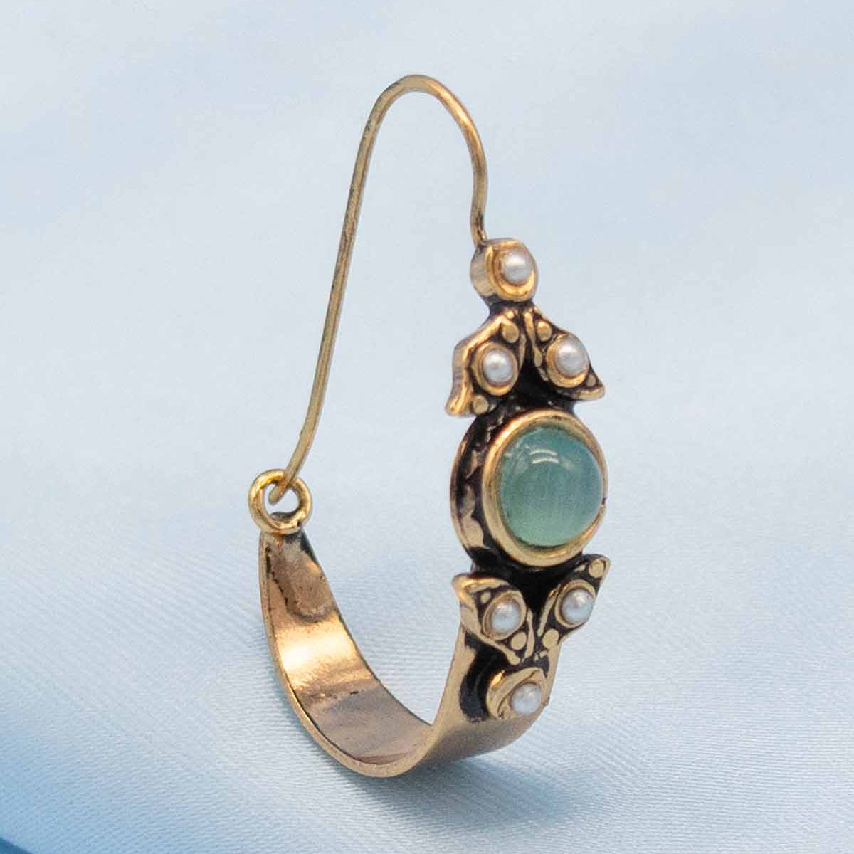 Gold earring with a green gemstone and pearls