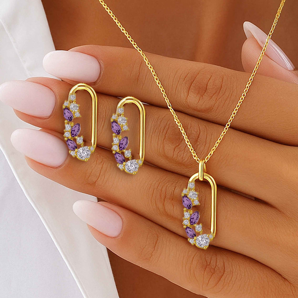 Gold jewelry set with purple gemstones on a hand against a neutral background