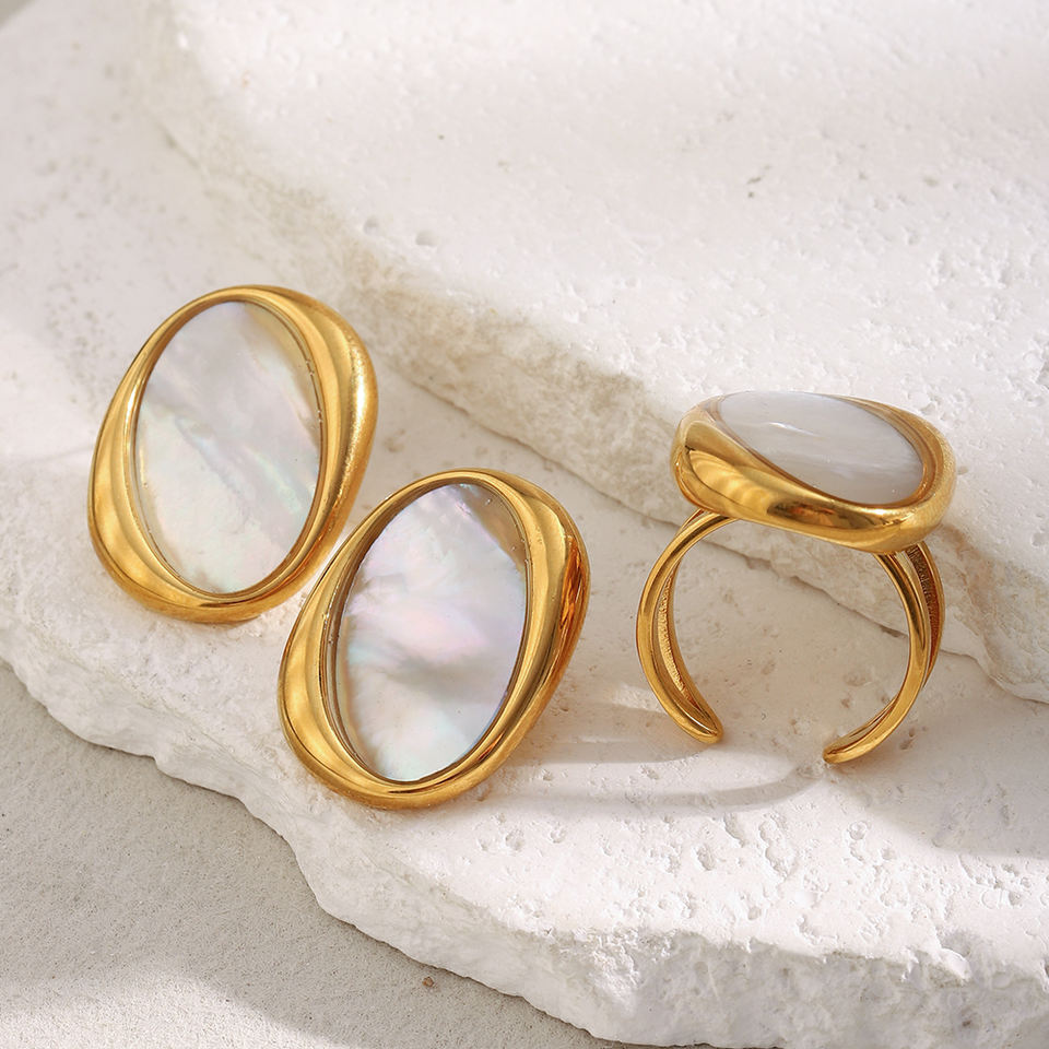 Gold rings with white stones on a textured white surface
