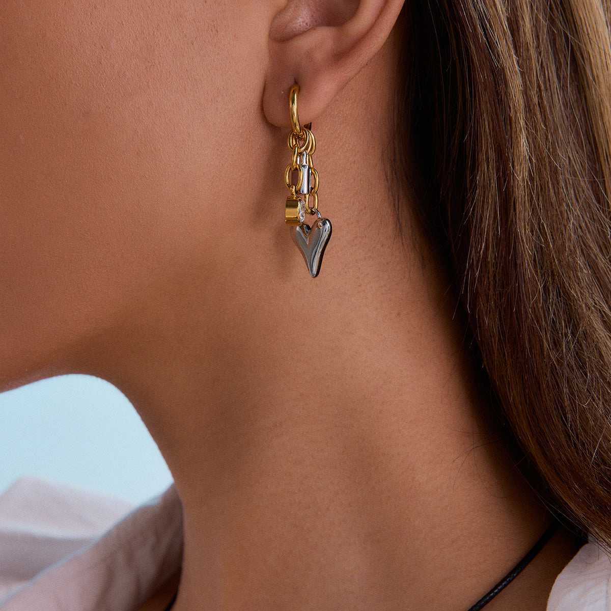 Gold earring with a heart charm 