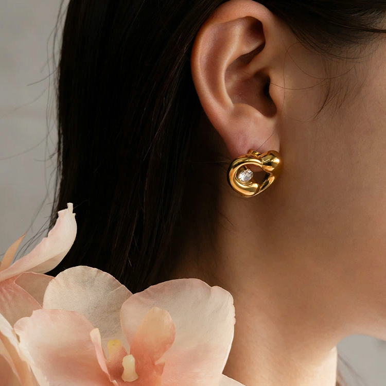 Gold earrings with a diamond on an ear, .