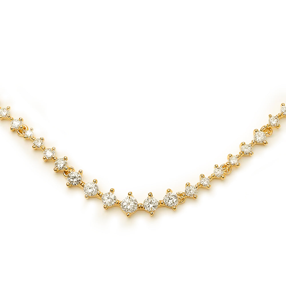 A close-up of a gold tennis necklace featuring round-cut diamonds in a symmetrical prong setting.